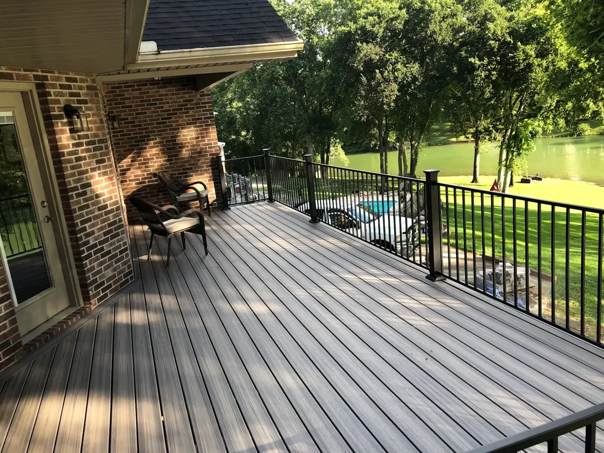 Deck with black metal railings and a chair overlooking a lawn