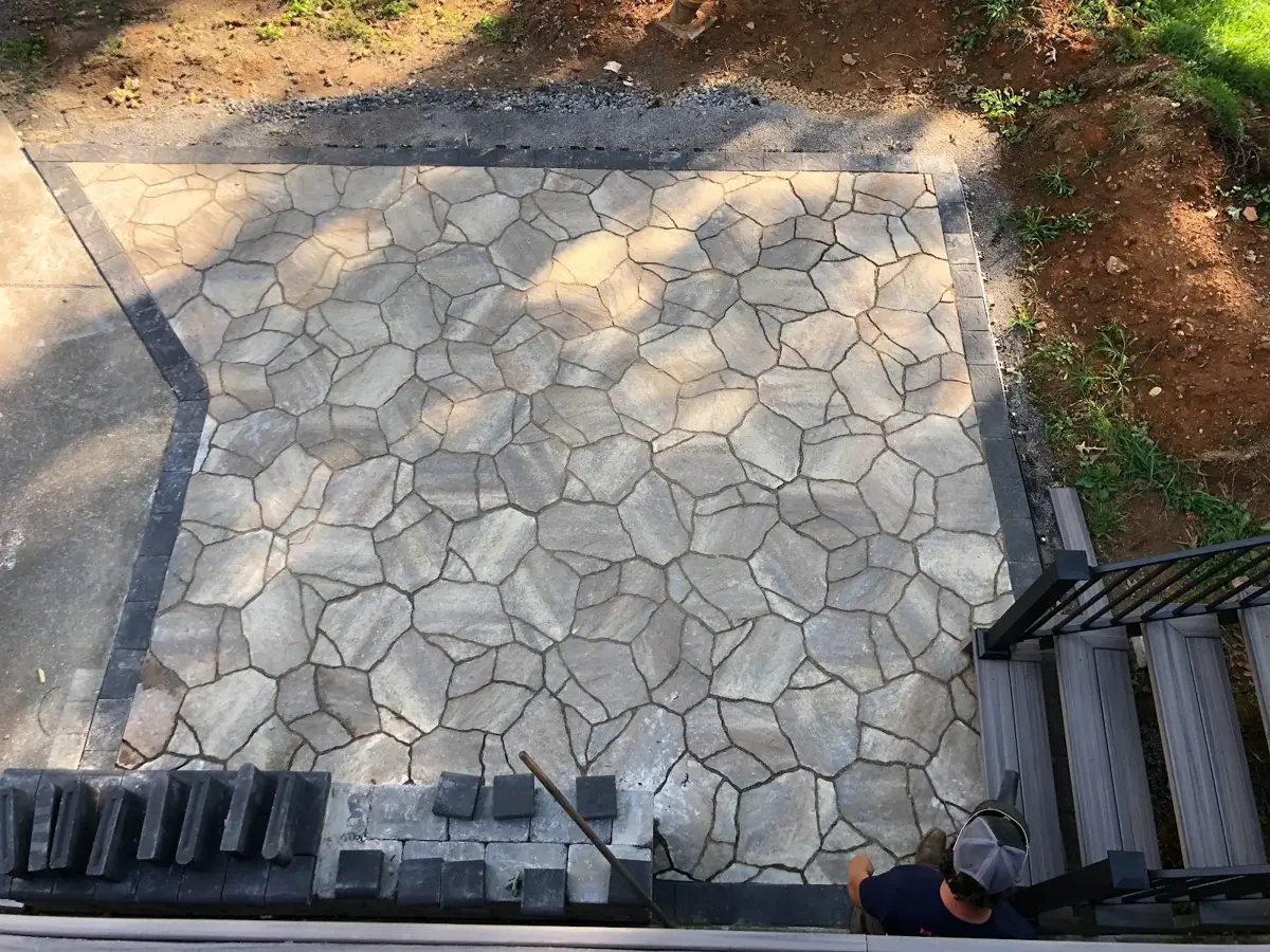 Newly installed flagstone-style paver patio with edging